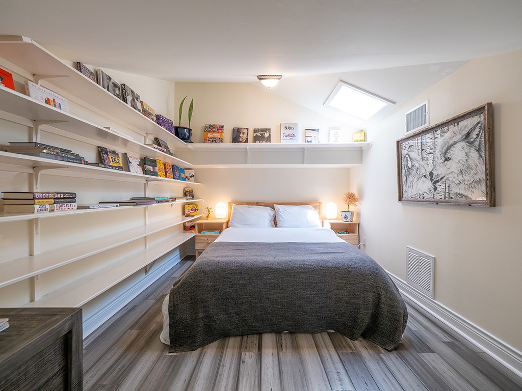 3609 Clawson Road, Unit B Austin, TX 78704 - Photo 22 of 28 Bedroom featuring extensive built-in shelving, wood-finish flooring, a vaulted ceiling, a skylight, and recessed lighting
