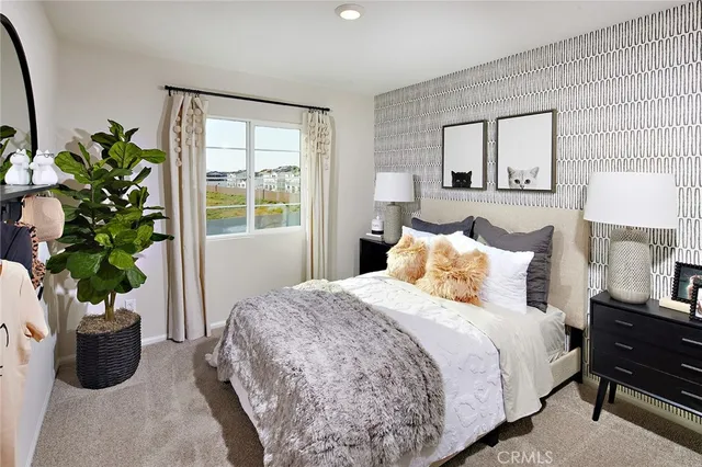 a bedroom with bed and a potted plant