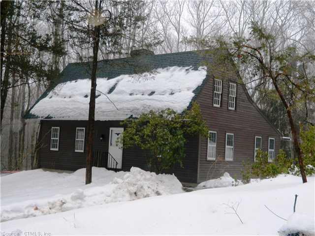 a front view of a house with a yard covered in snow