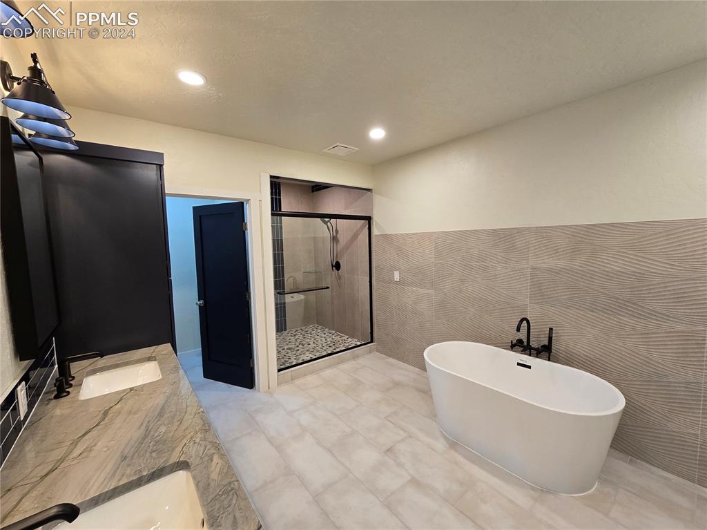 33036 Meadow Ridge Lane Trinidad, CO 81082 - Photo 41 of 50 Lower level bathroom with tile walls, independent shower and soaking tub, and vanity