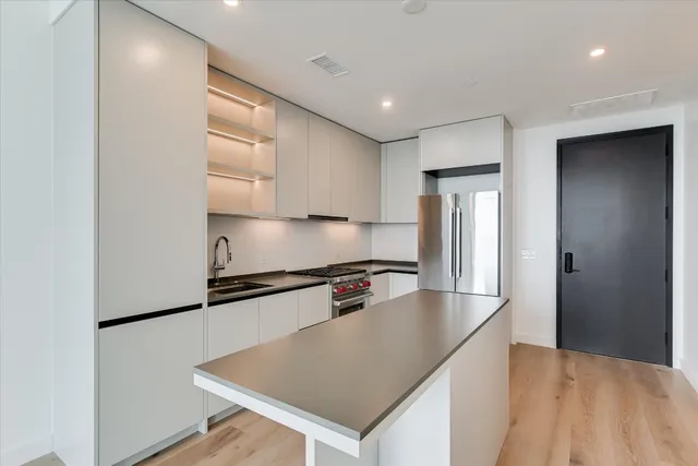 a kitchen with stainless steel appliances granite countertop a sink a stove and a refrigerator