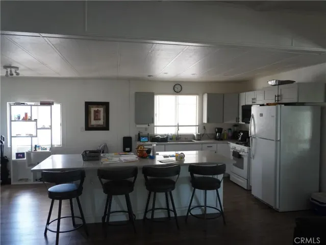 a kitchen with a dining table chairs refrigerator and cabinets