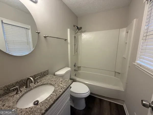 a bathroom with a granite countertop sink toilet and shower