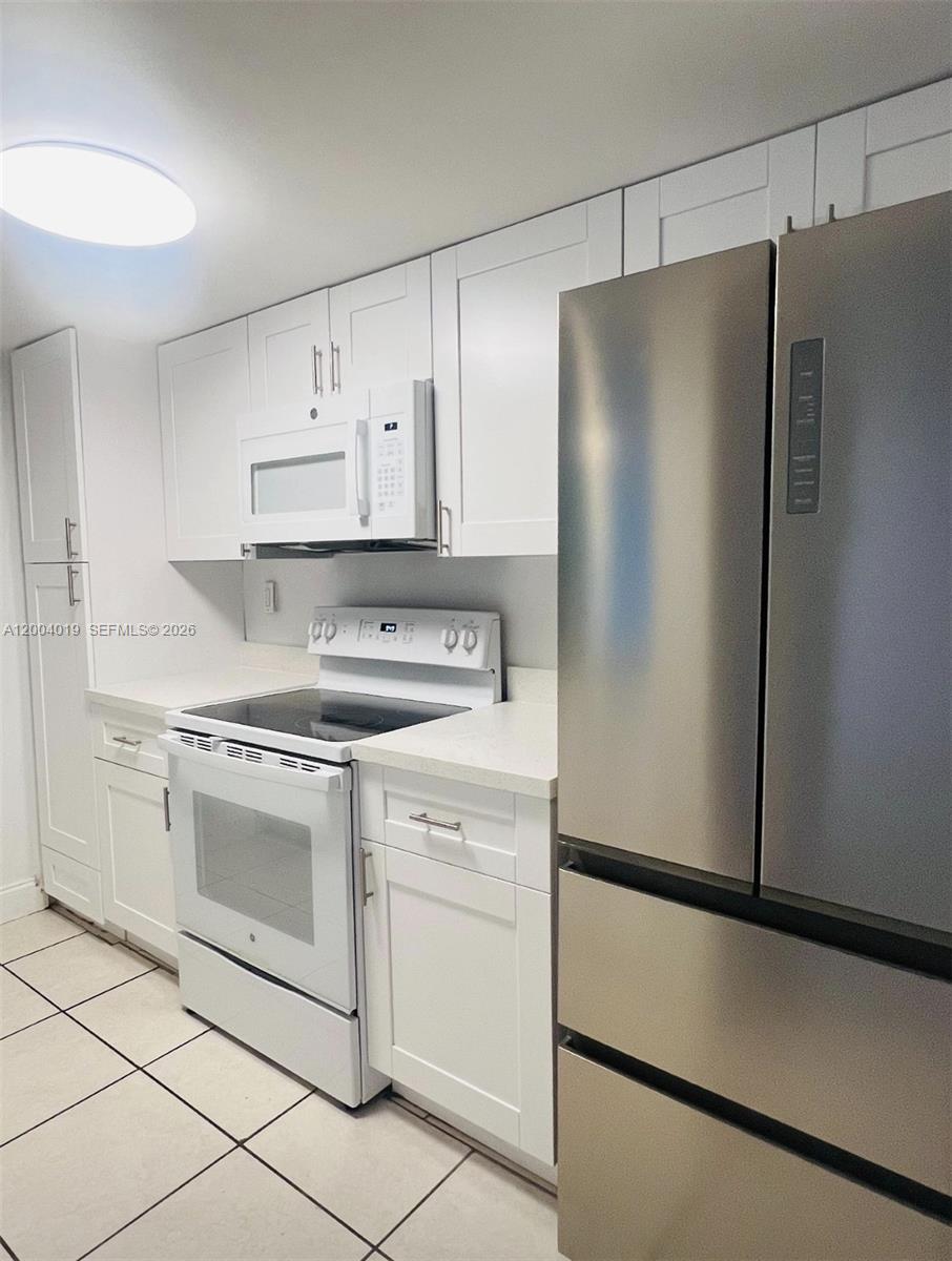 7075 Northwest 186th Street, Unit C205 Hialeah, FL 33015 - Photo 1 of 4 a kitchen with cabinets and stainless steel appliances