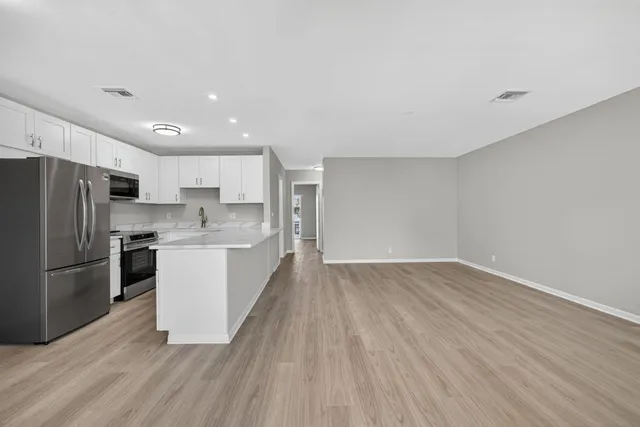 a kitchen with a refrigerator sink and cabinets