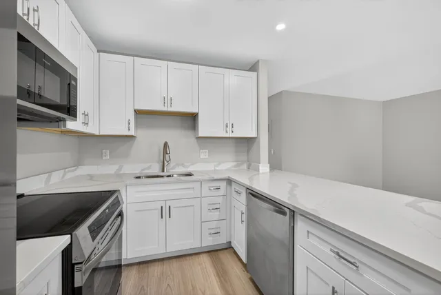 a kitchen with a sink dishwasher stove and cabinets