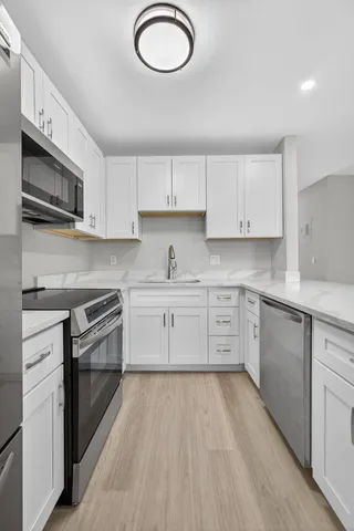 a kitchen with stainless steel appliances granite countertop a stove a sink and a microwave