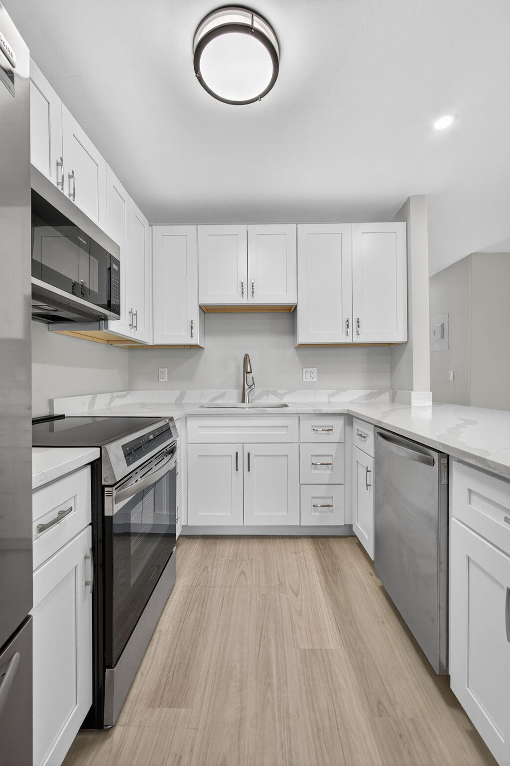 42 Easthampton B West Palm Beach, FL 33417 - Photo 15 of 37 a kitchen with stainless steel appliances granite countertop a stove a sink and a microwave