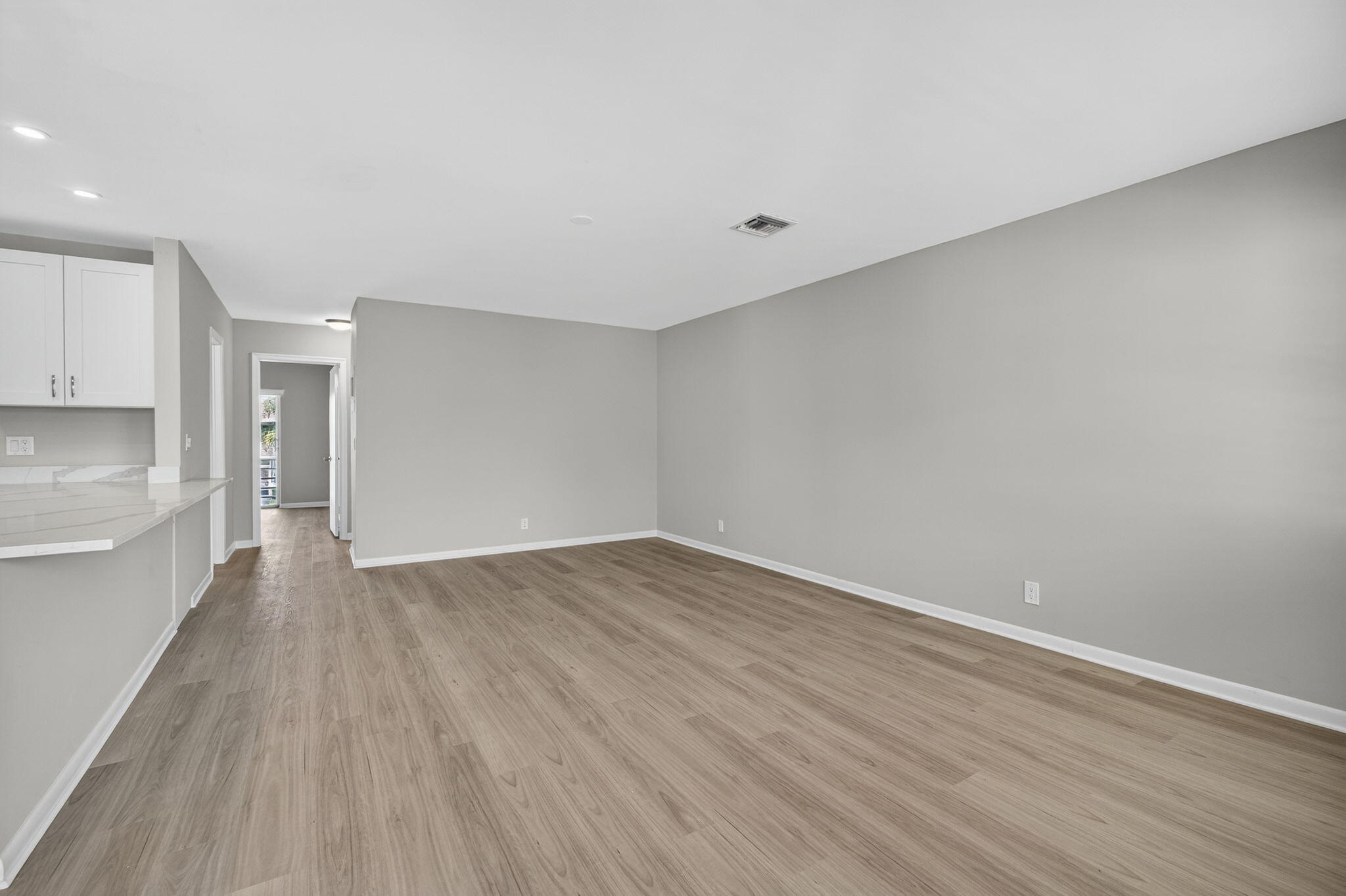 42 Easthampton B West Palm Beach, FL 33417 - Photo 2 of 37 a view of an empty room with wooden floor and a window
