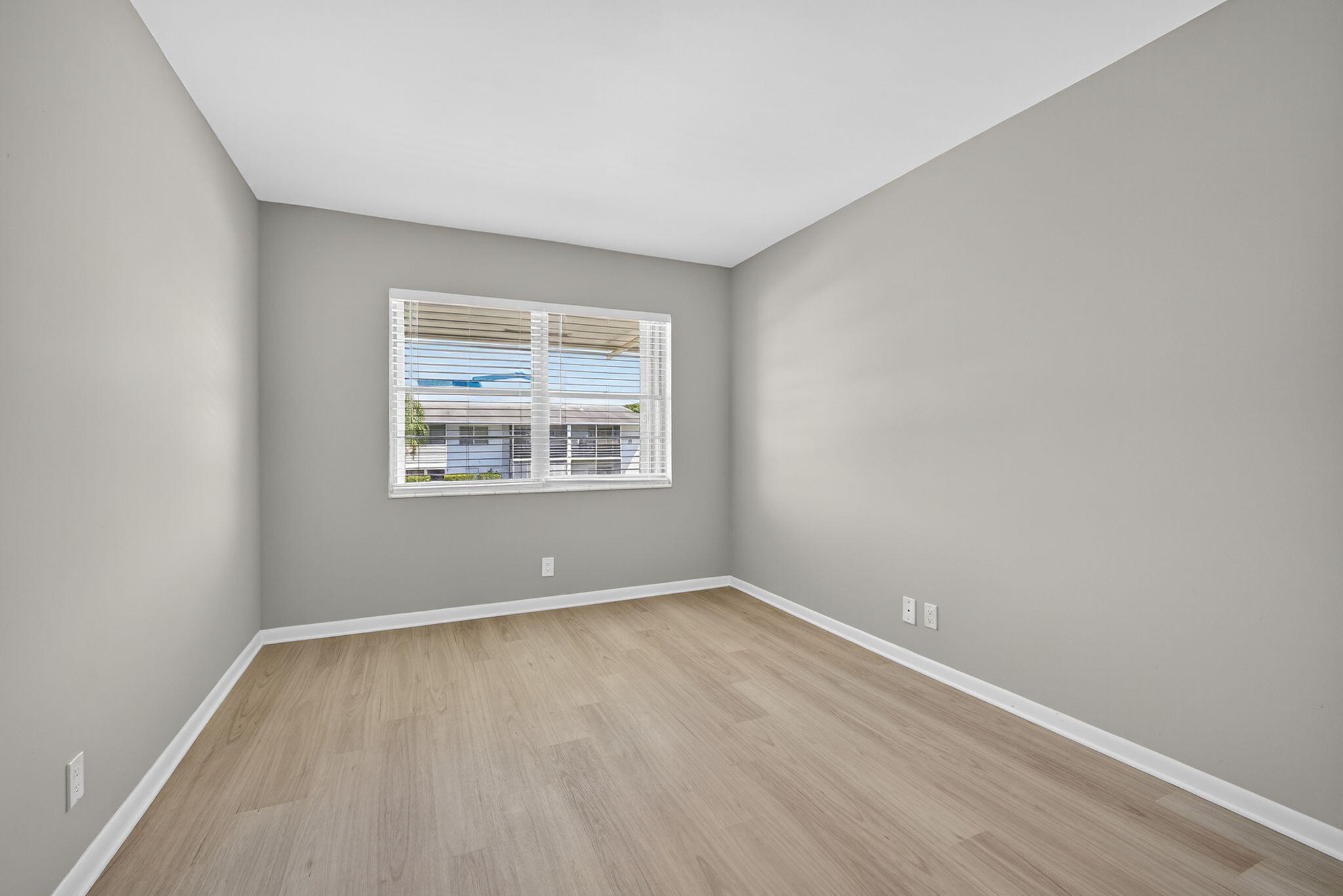 42 Easthampton B West Palm Beach, FL 33417 - Photo 22 of 37 an empty room with wooden floor and windows