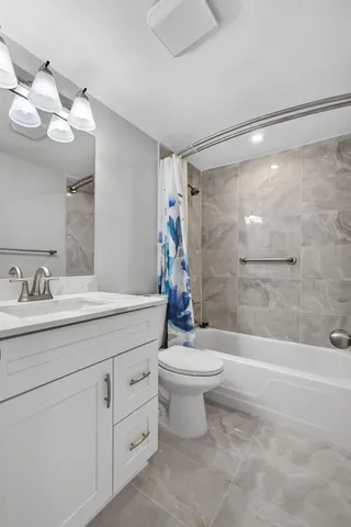 a bathroom with a double vanity sink toilet and shower