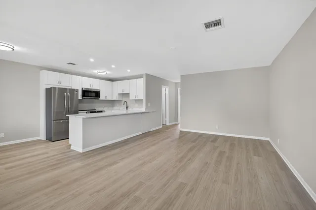 a view of kitchen with stainless steel appliances refrigerator stove microwave and cabinets