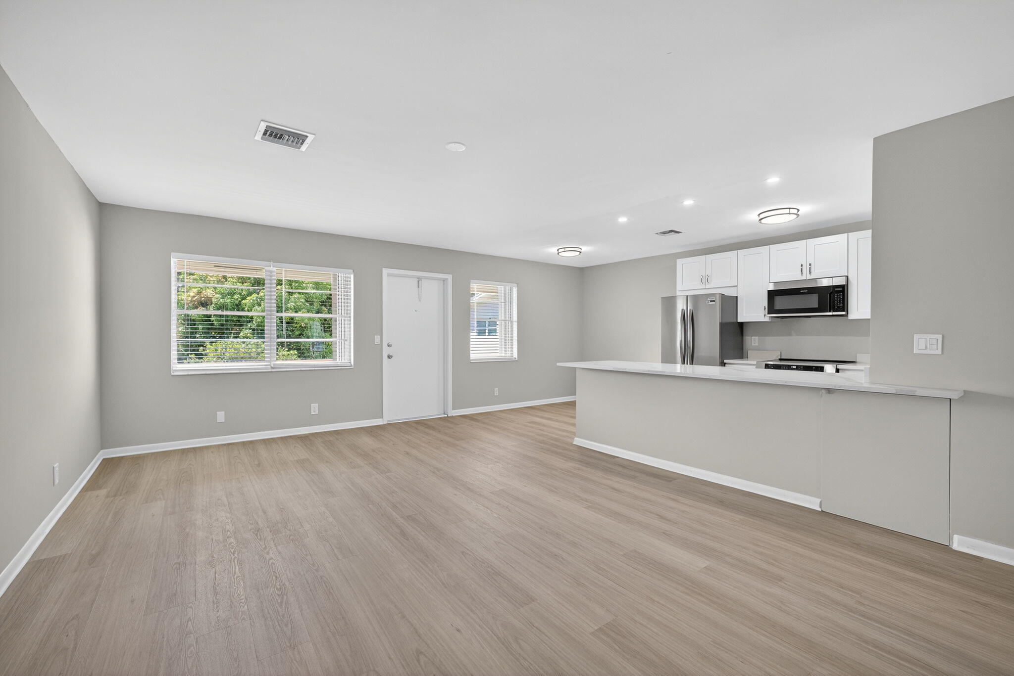 42 Easthampton B West Palm Beach, FL 33417 - Photo 4 of 37 a view of an empty room with window and wooden floor