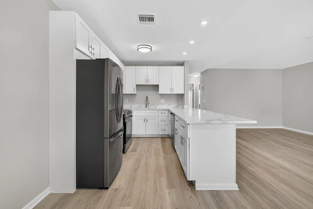 a kitchen with white cabinets and stainless steel appliances