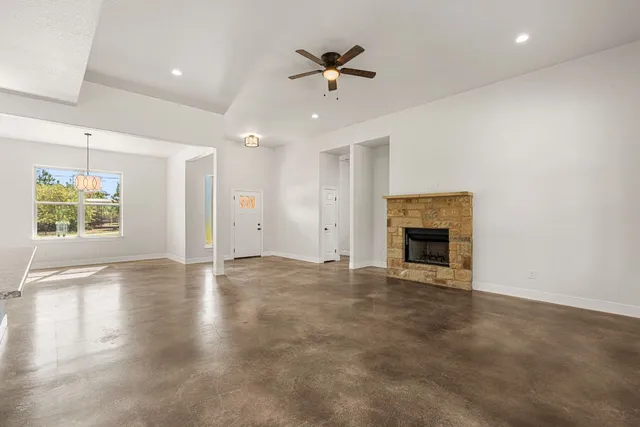 an empty room with windows and fireplace