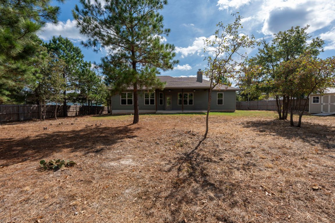 203 Cardinal Loop Paige, TX 78659 - Photo 28 of 36 a house with trees in front of it