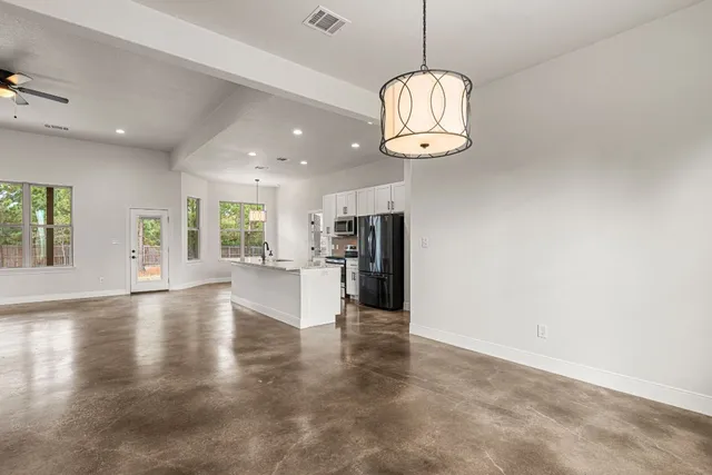 an empty space with kitchen view and wooden floor
