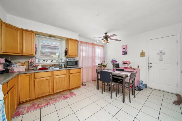 a kitchen with granite countertop a sink cabinets and dining table chair