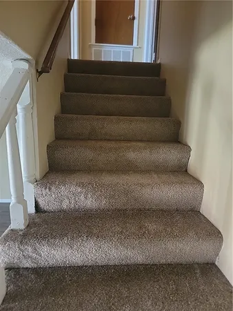 a living room with furniture and a stair