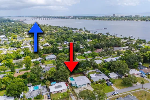 an aerial view of a house with a garden and lake view