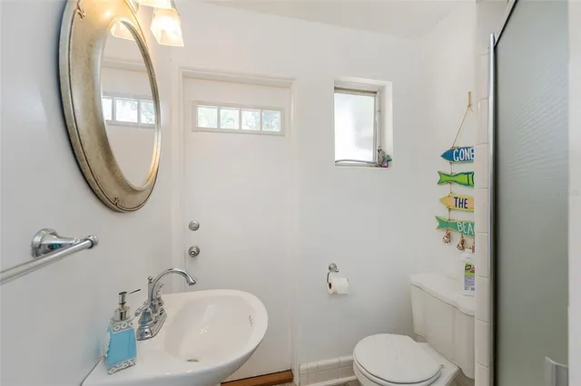 a bathroom with a sink toilet and a mirror