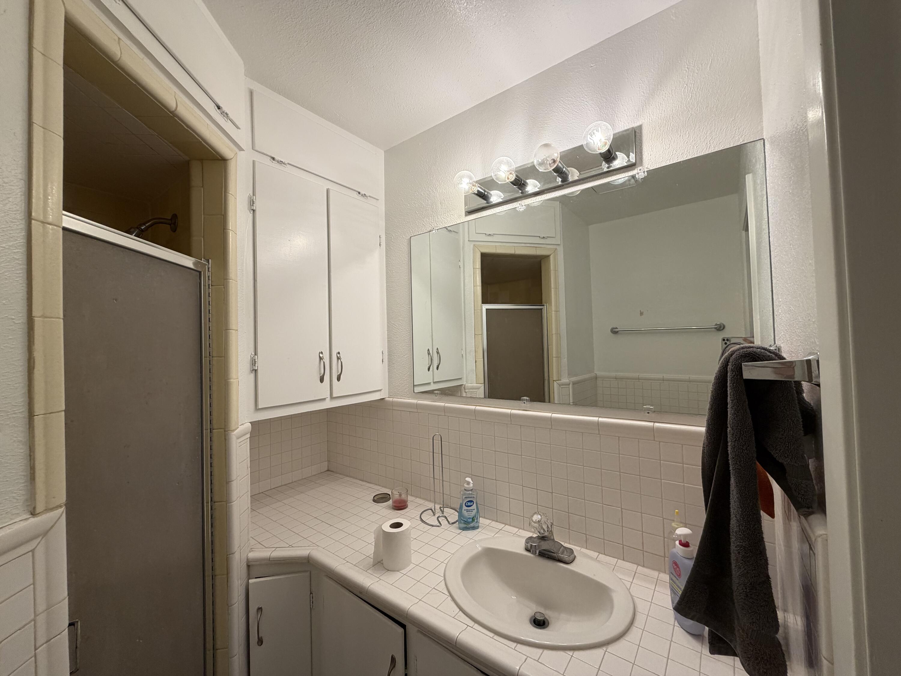 2202 58th Street Lubbock, TX 79412 - Photo 18 of 37 a bathroom with a sink and a mirror