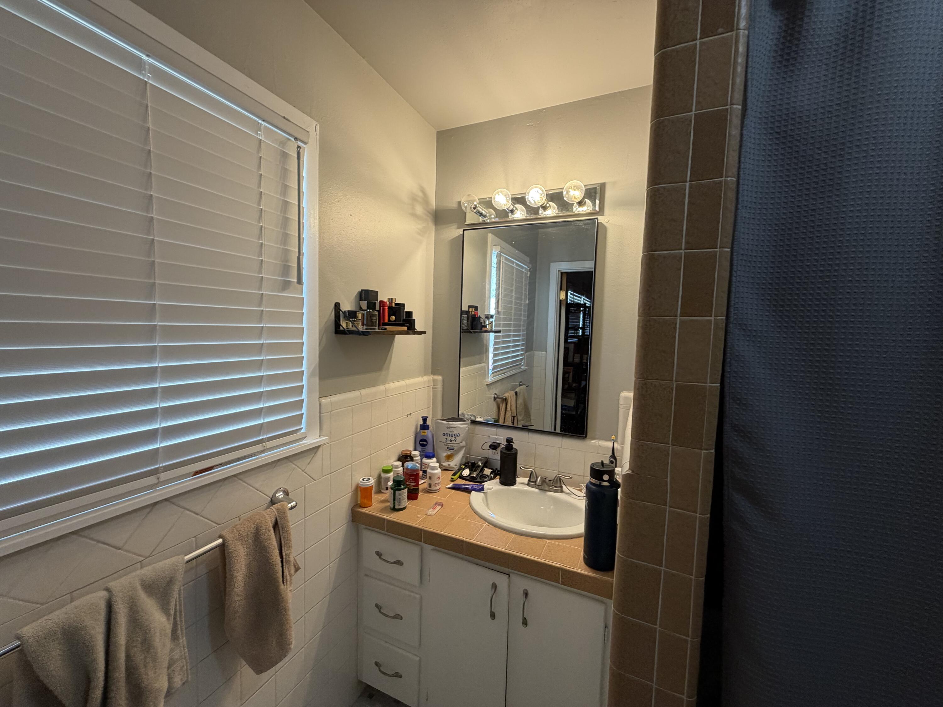 2202 58th Street Lubbock, TX 79412 - Photo 23 of 37 a bathroom with a sink and mirror