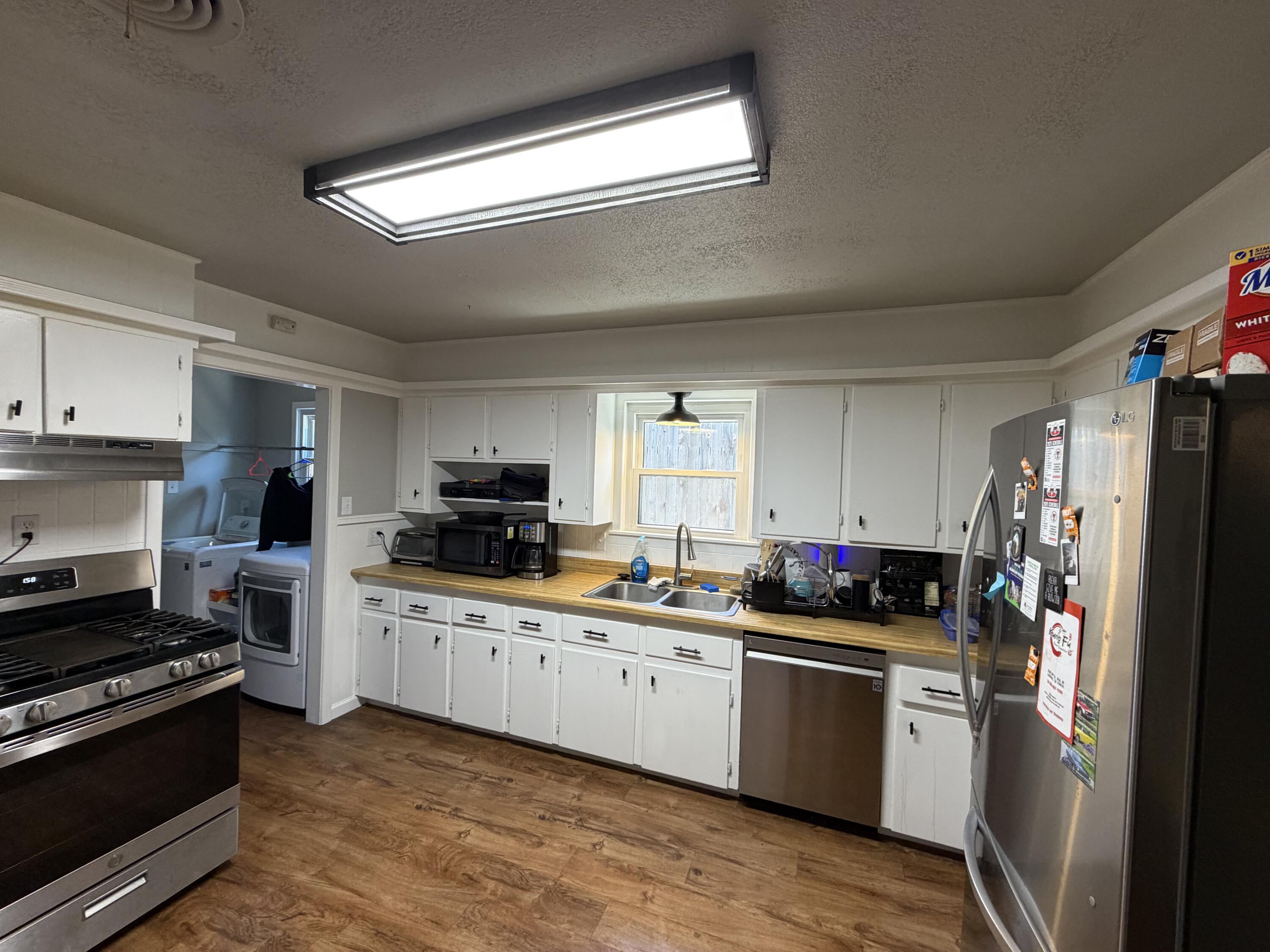 2202 58th Street Lubbock, TX 79412 - Photo 3 of 37 a kitchen with stainless steel appliances a refrigerator sink and white cabinets