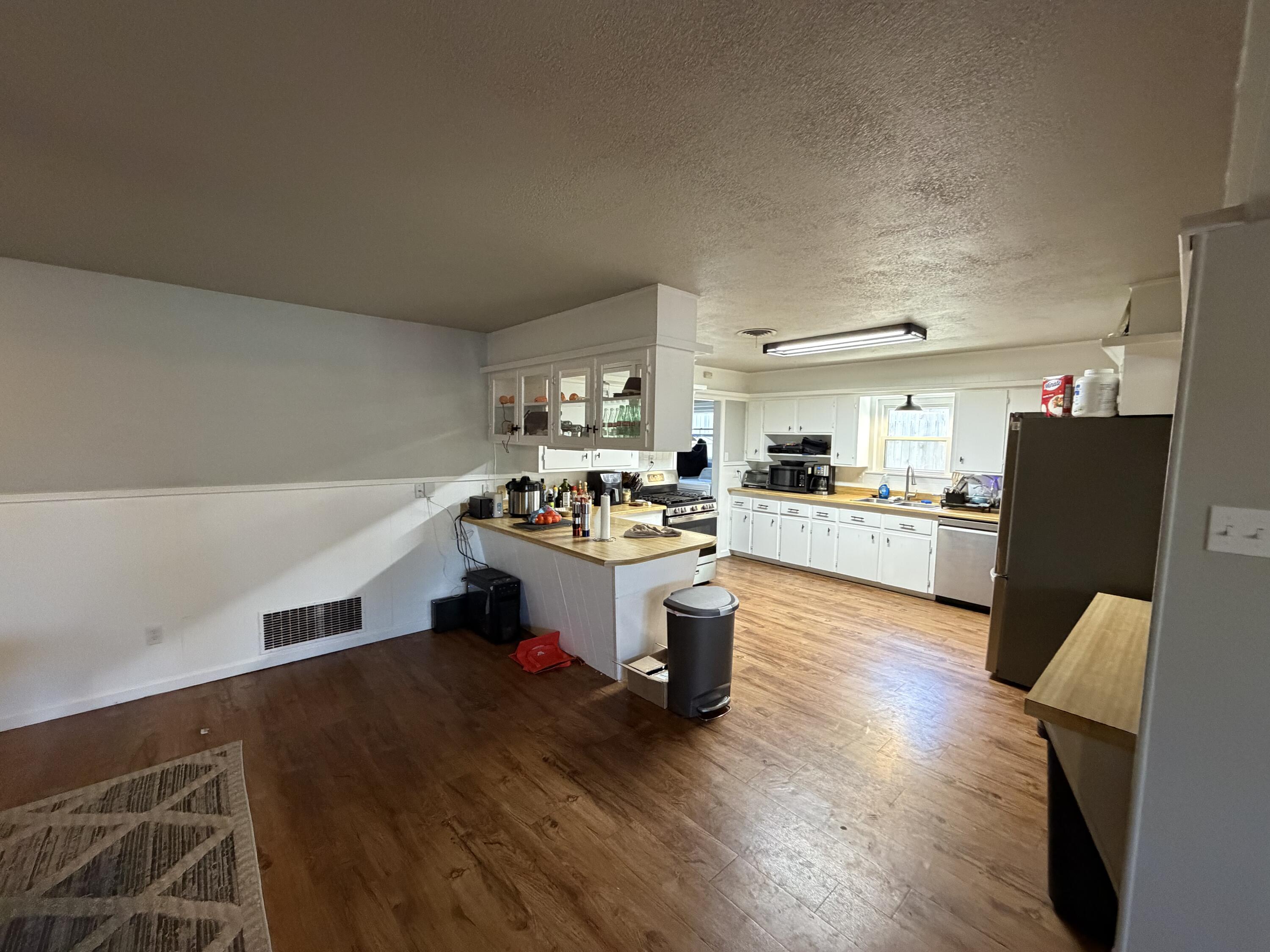 2202 58th Street Lubbock, TX 79412 - Photo 5 of 37 a kitchen with a refrigerator and wooden cabinets