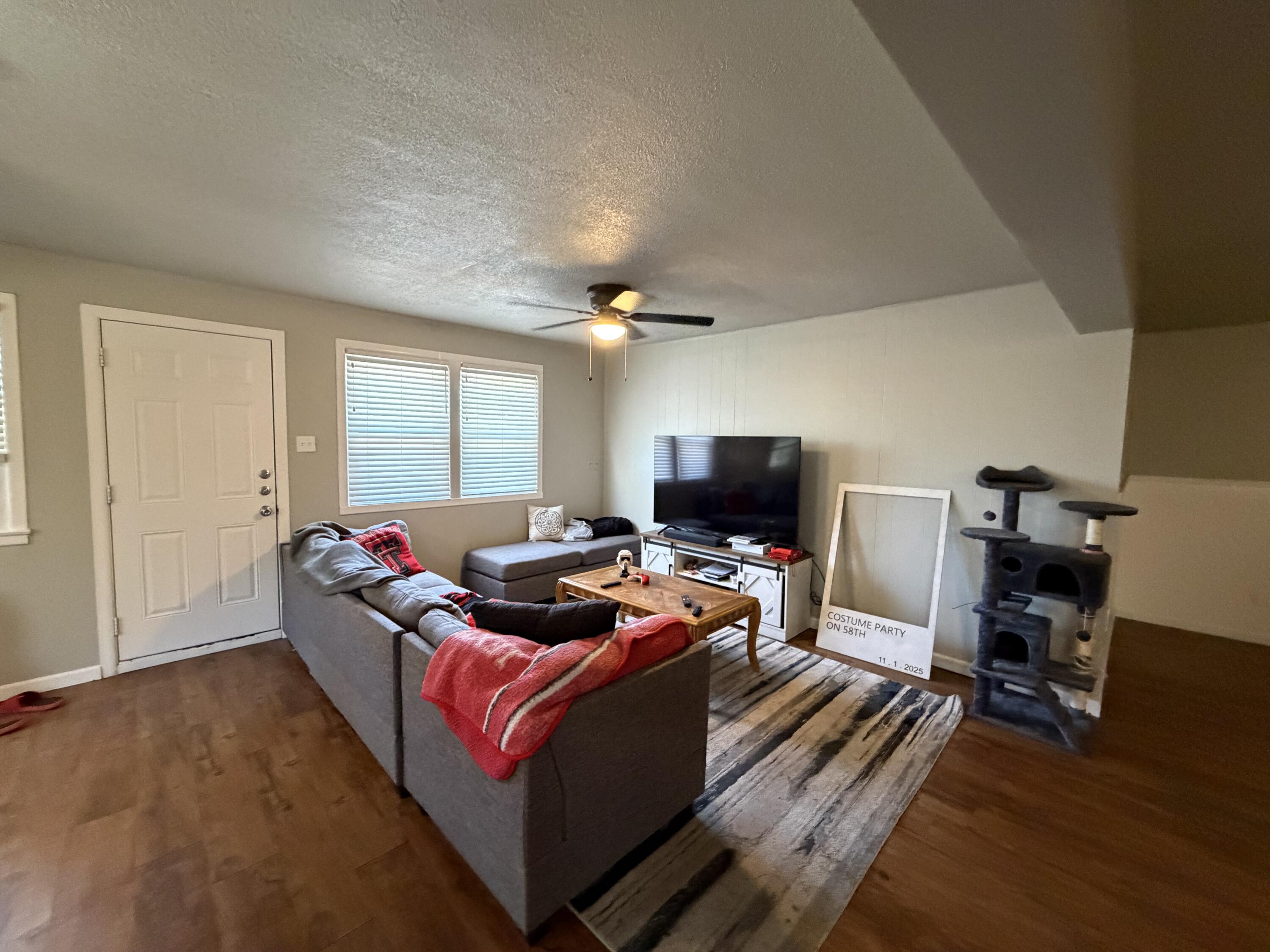 2202 58th Street Lubbock, TX 79412 - Photo 8 of 37 a living room with furniture a flat screen tv and a window
