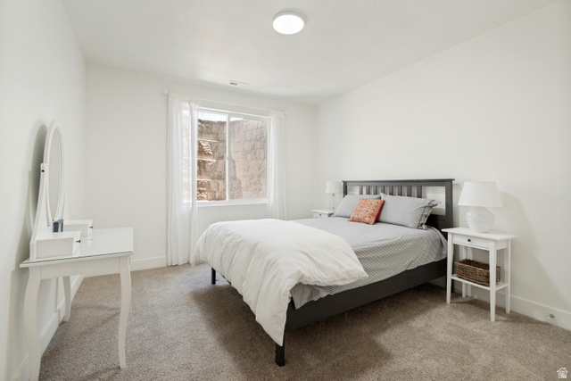 683 Kings Landing Tooele, UT 84074 - Photo 19 of 39 Carpeted bedroom with a window featuring white sheers, a flush-mount ceiling light, white baseboards, and white painted walls