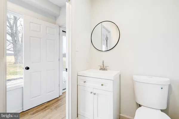 a bathroom with a toilet a sink and a mirror