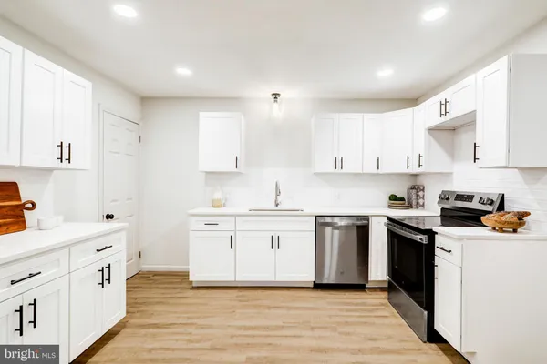 a kitchen with white cabinets stainless steel appliances and sink