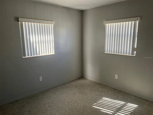 an empty room with windows and closet