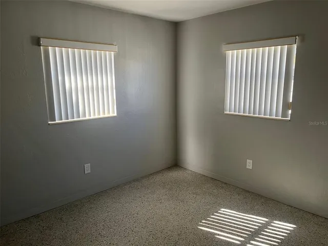 an empty room with windows and closet