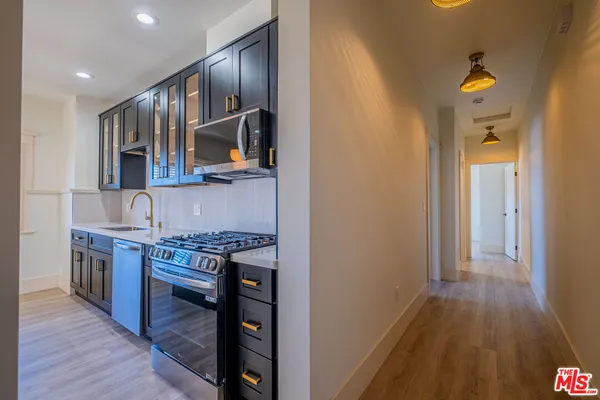 a kitchen with stainless steel appliances granite countertop a stove and a wooden floors