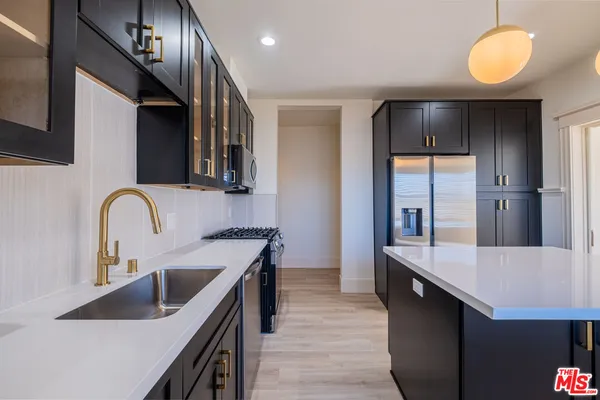 a kitchen with kitchen island a sink stainless steel appliances and cabinets