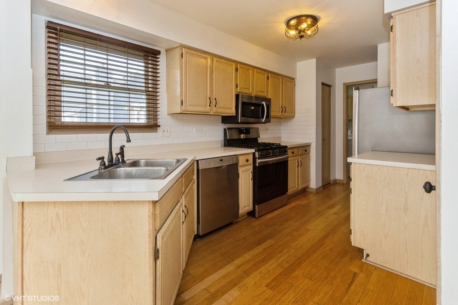 4418 Riverside Drive Plainfield, IL 60586 - Photo 4 of 21 a kitchen with stainless steel appliances granite countertop a sink a stove a refrigerator with grey cabinets and wooden floor