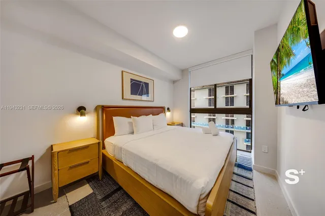 a bed room with a bed and a painting on the wall