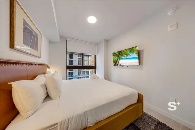 a bedroom with a bed and a flat screen tv