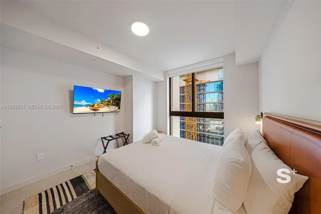 a bedroom with a bed and a large window