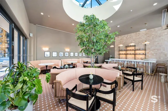 a dining room with furniture and a potted plant