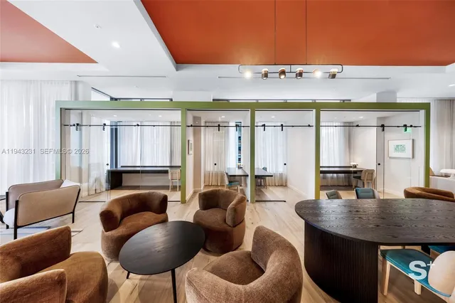a living room with furniture a large window and potted plants