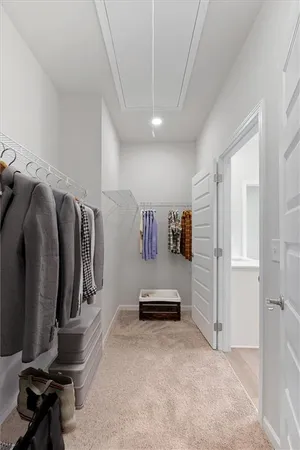 a view of walk in closet with clothes and shoes