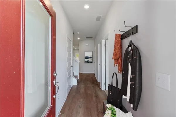 a view of a hallway with wooden floor and staircase