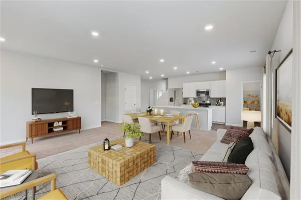 a living room with furniture kitchen view and a flat screen tv