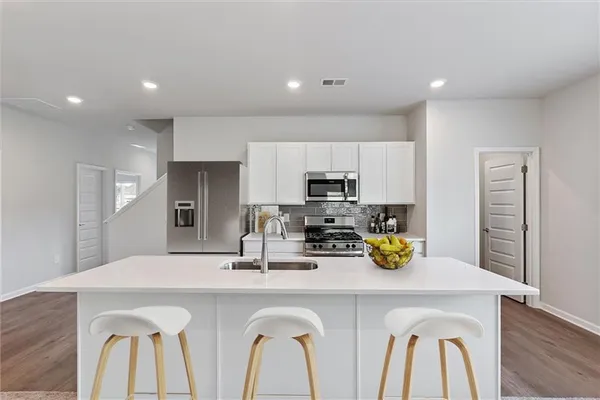 a kitchen with stainless steel appliances a sink refrigerator and microwave