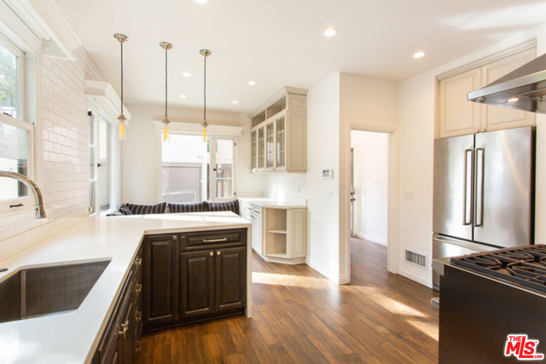 153 North Arnaz Drive Beverly Hills, CA 90211 - Photo 12 of 20 a kitchen with stainless steel appliances granite countertop a sink stove and refrigerator