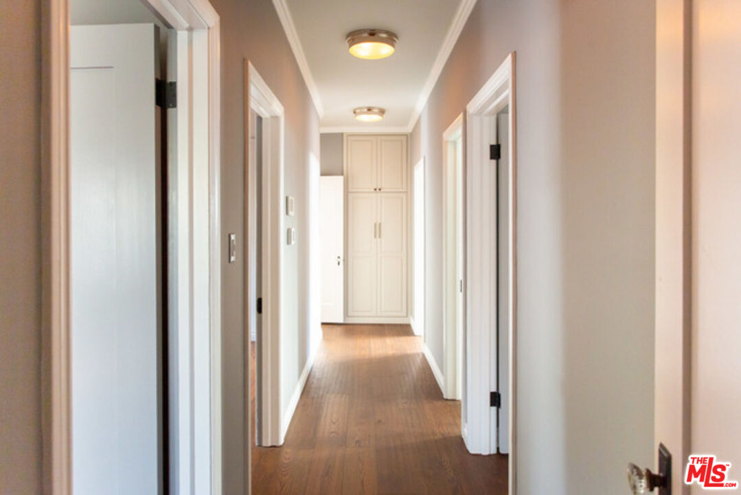 153 North Arnaz Drive Beverly Hills, CA 90211 - Photo 14 of 20 a view of a hallway with wooden floor and a bathroom