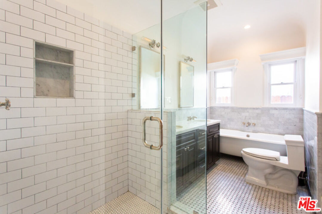 153 North Arnaz Drive Beverly Hills, CA 90211 - Photo 17 of 20 a bathroom with a granite countertop toilet a sink and a shower